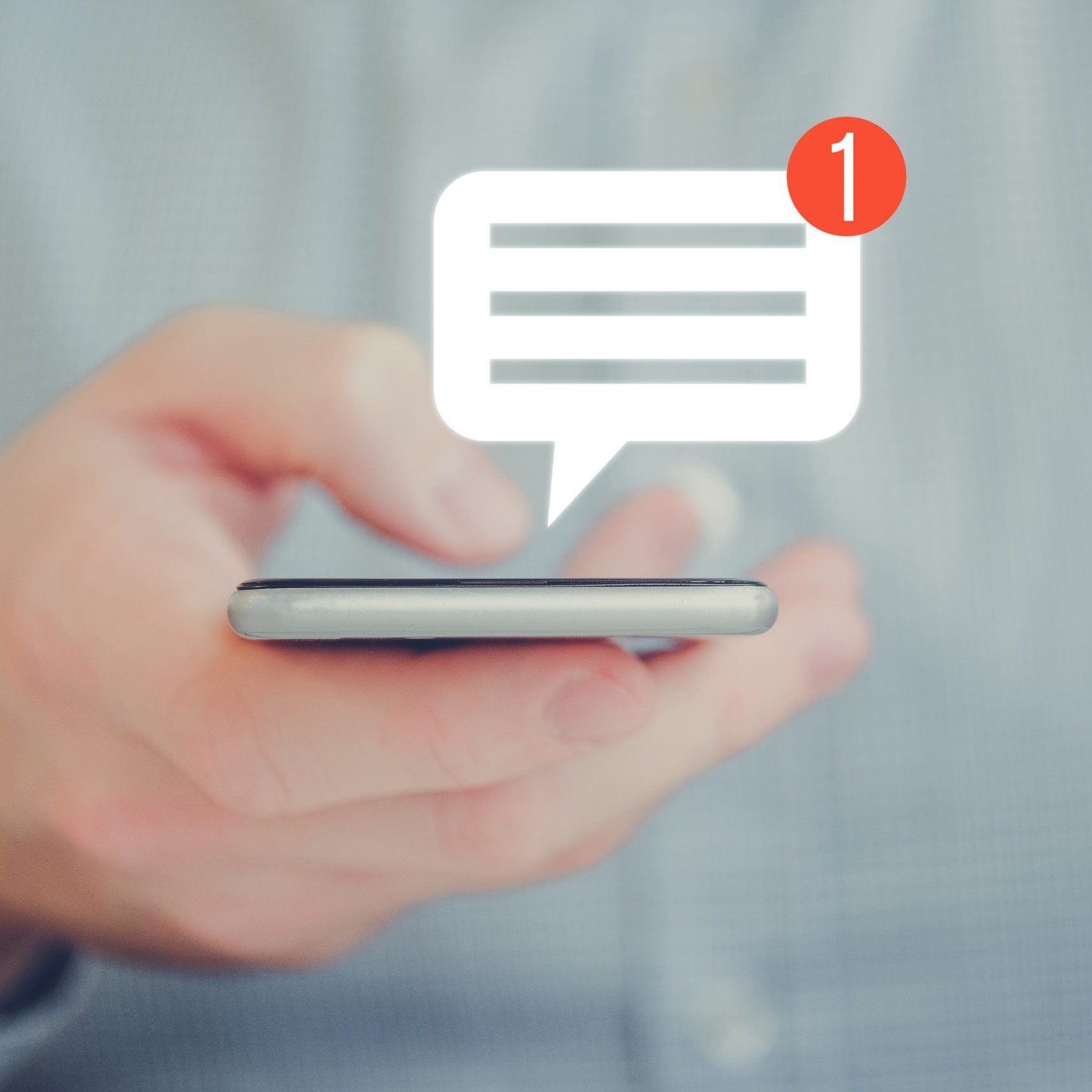 A man in a shirt holds a smartphone with his hand. Abstract notification message icon. Social networking concept. Close up.